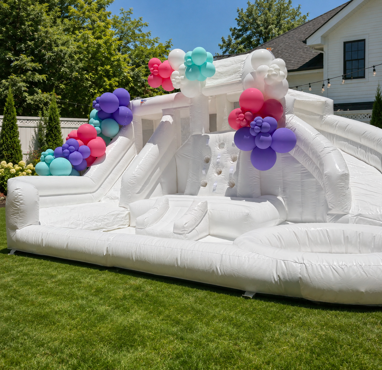 Modern white splash pad water inflatable set up in a Dallas backyard for a summer birthday party